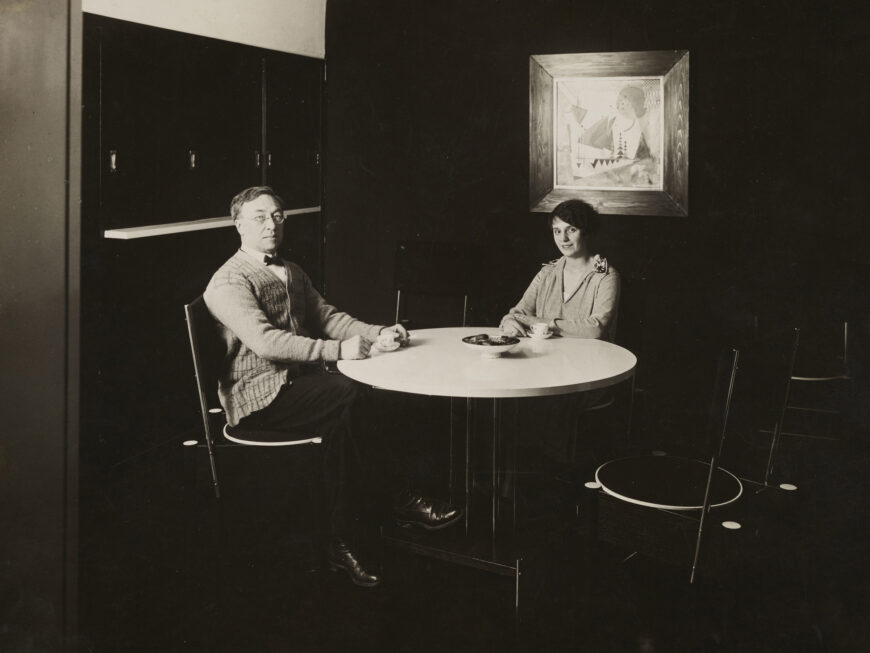 A black-and-white photograph of artist Vasily Kandinsky and his wife, Nina, sitting at their dining table in their home at the Bauhaus.